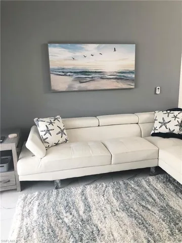 a living room with furniture and white wall