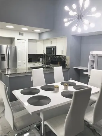 a kitchen with a dining table chairs and a refrigerator