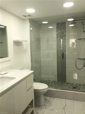 a bathroom with a sink a toilet and shower