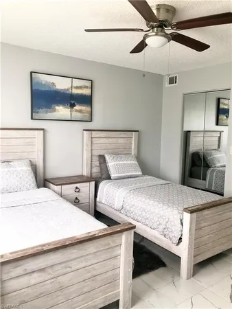 a bedroom with two bed and a chandelier