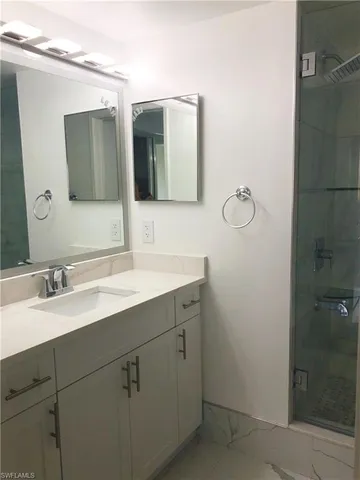a bathroom with a double vanity sink mirror and shower