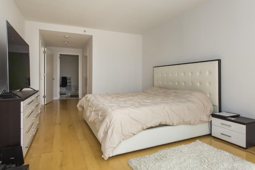 2 2nd Street, Unit 3304 Jersey City, NJ 07302 - Photo 11 of 25 a spacious bedroom with a bed and a flat screen tv