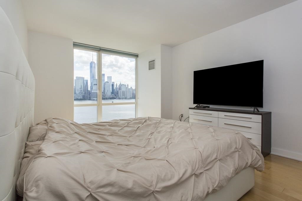 2 2nd Street, Unit 3304 Jersey City, NJ 07302 - Photo 10 of 25 a bedroom with a bed and a flat screen tv