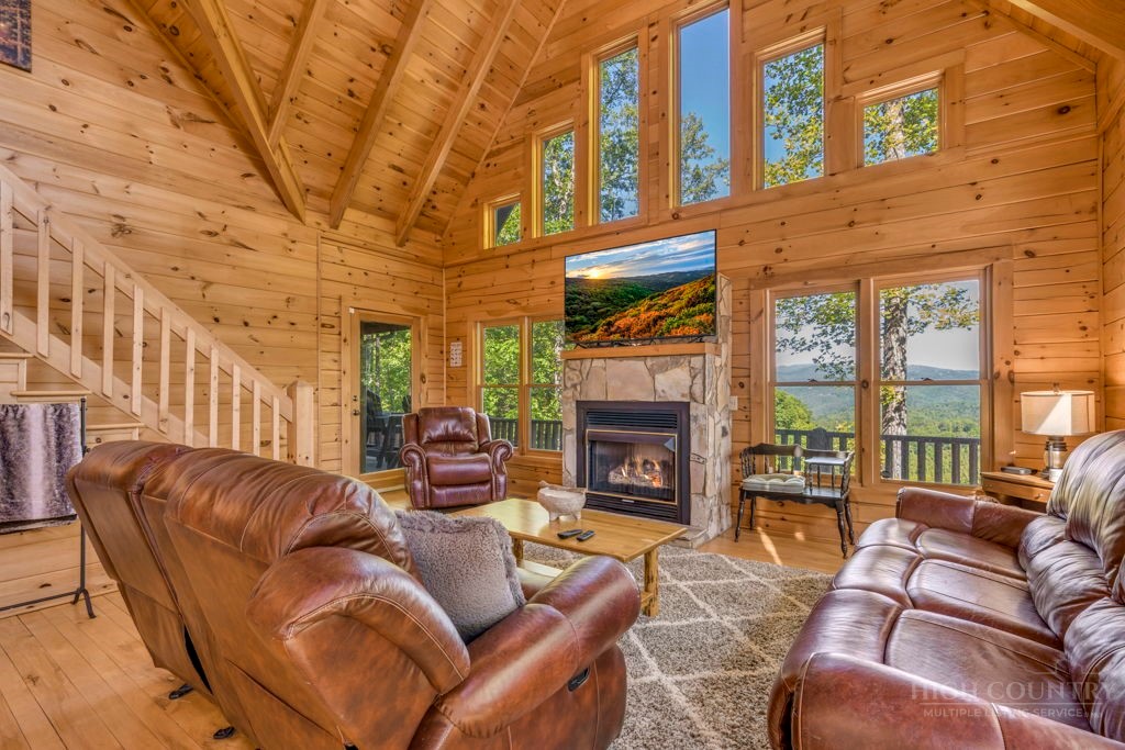 2229 Elk Ridge Road Ferguson, NC 28624 - Photo 15 of 42 a living room with furniture a fireplace and floor to ceiling windows