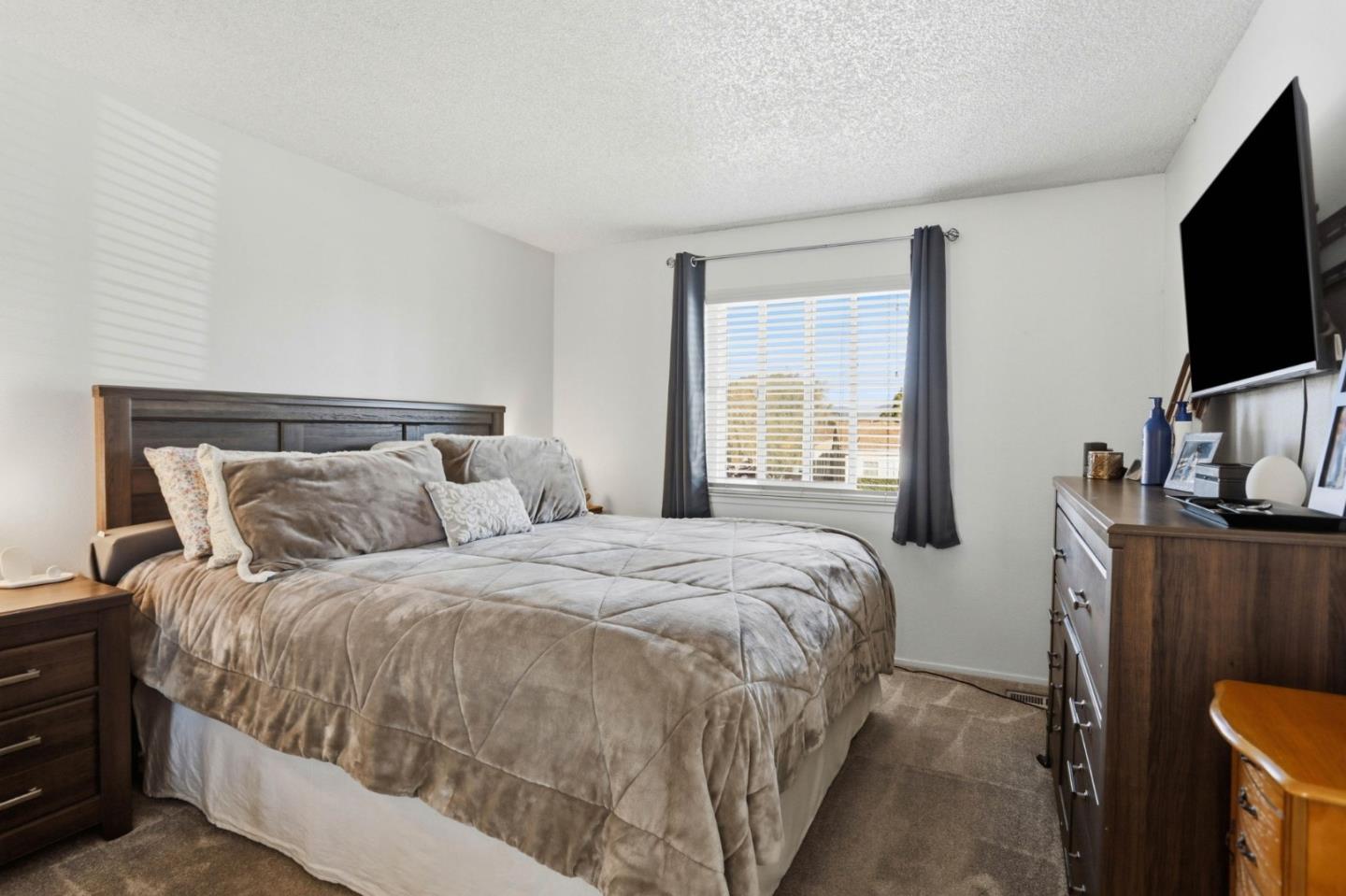 1075 Sherman Drive Salinas, CA 93907 - Photo 16 of 24 a bedroom with a bed and a flat tv screen on a dresser
