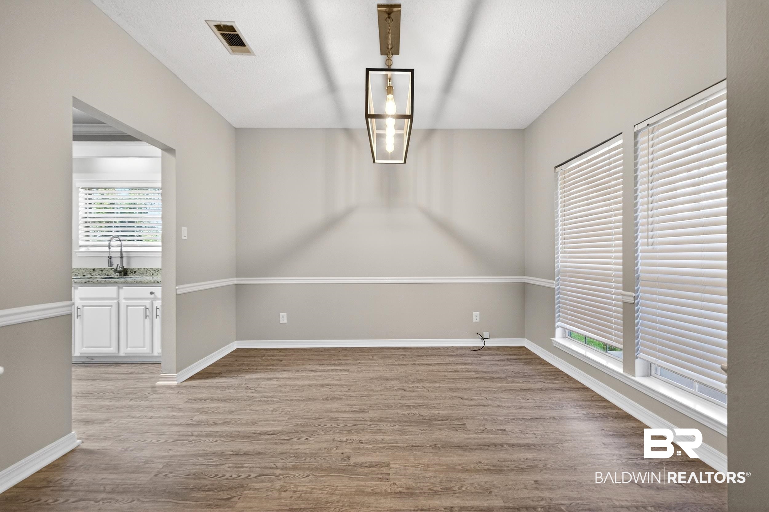 7050 Highpointe Place West Daphne, AL 36527 - Photo 11 of 66 Unfurnished dining area featuring dark wood-type flooring and baseboards