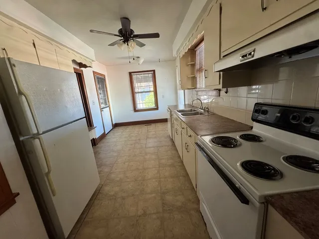 a kitchen with a stove a refrigerator and a window