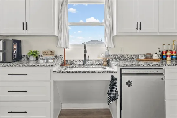 a kitchen with cabinets appliances a sink and a counter top space