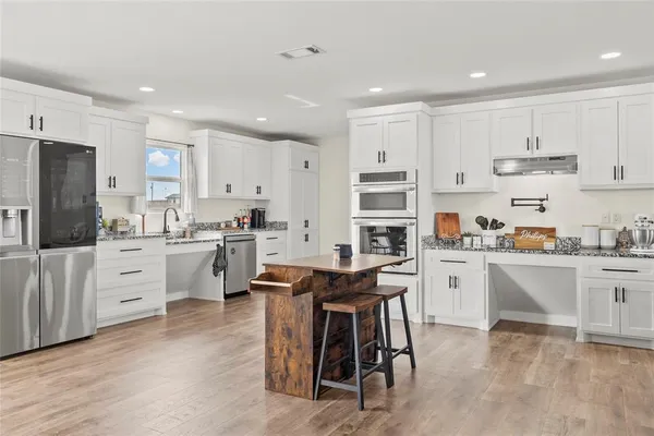 a kitchen with white cabinets and stainless steel appliances