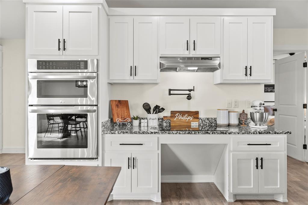 170 Private Road Brookston, TX 75421 - Photo 14 of 33 a kitchen with stainless steel appliances granite countertop a stove a sink dishwasher and white cabinets with wooden floor