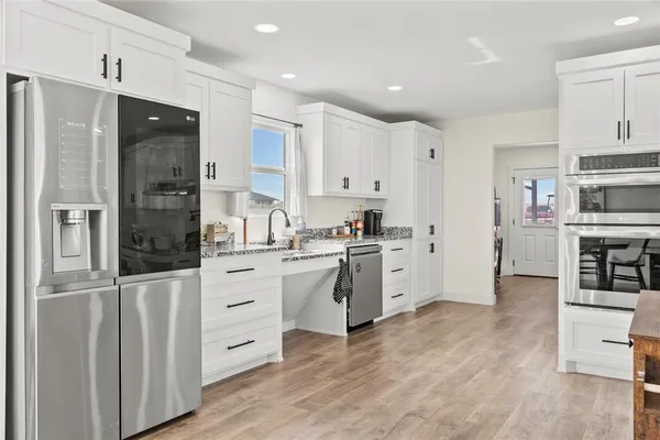 a kitchen with white cabinets and stainless steel appliances