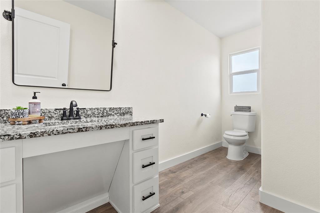 170 Private Road Brookston, TX 75421 - Photo 19 of 33 a bathroom with a granite countertop toilet sink and a mirror