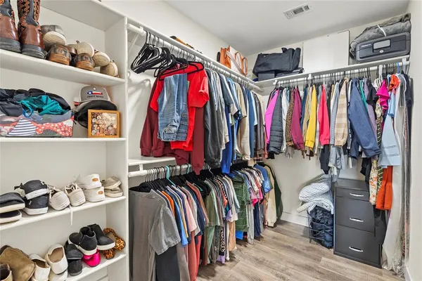 a view of walk in closet with clothes and shoes