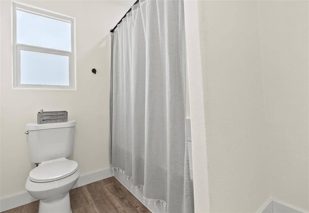 170 Private Road Brookston, TX 75421 - Photo 30 of 33 a bathroom with a toilet a sink and a shower curtain