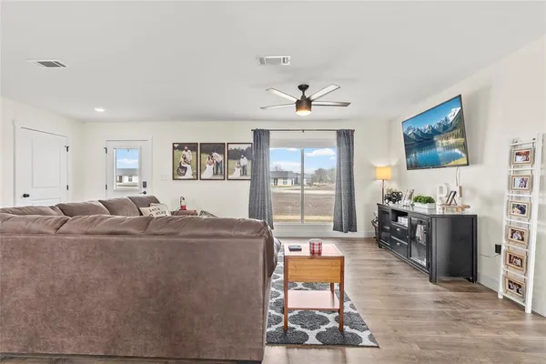 a living room with furniture a flat screen tv and a fireplace