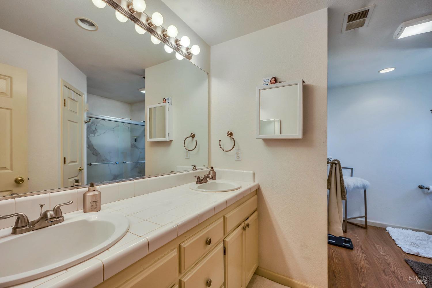 921 Chiles Avenue St. Helena, CA 94574 - Photo 13 of 20 a bathroom with a double vanity sink mirror and shower