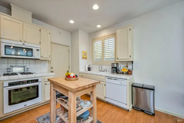 a kitchen with stainless steel appliances a stove a sink a stove a microwave and a refrigerator