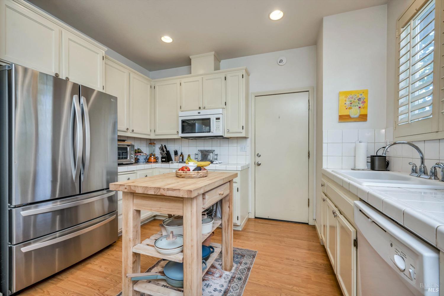 921 Chiles Avenue St. Helena, CA 94574 - Photo 9 of 20 a kitchen with stainless steel appliances a refrigerator sink and white cabinets