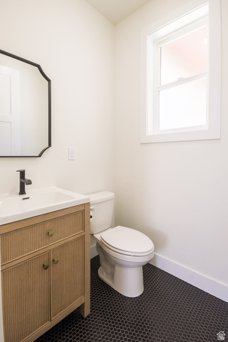 3322 250 S Street Vernal, UT 84078 - Photo 11 of 37 Bathroom featuring a light wood-finish vanity with fluted details, a white integrated sink, and a matte black faucet