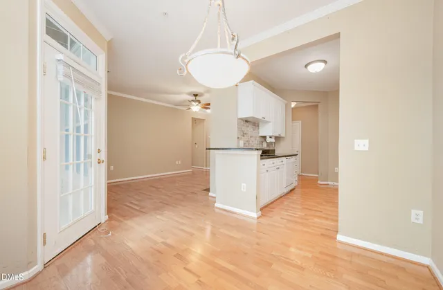 a view of a kitchen with wooden floor and a refrigerator