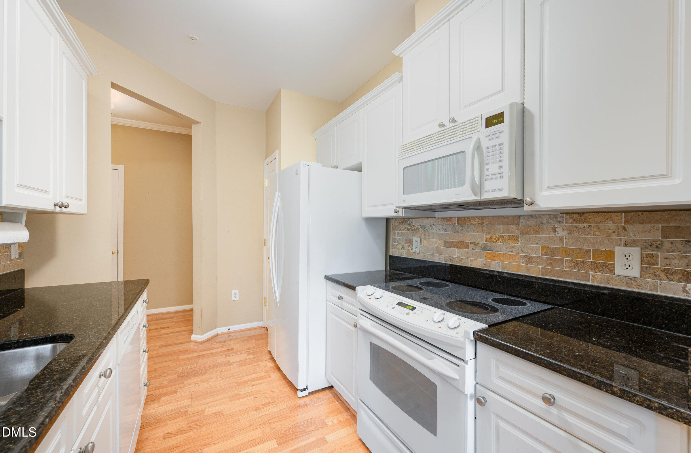 8041 Allyns Landing Way, Unit 101 Raleigh, NC 27615 - Photo 13 of 32 a kitchen with white cabinets and appliances