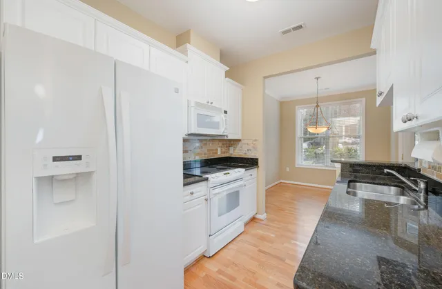 a kitchen with granite countertop a stove and a refrigerator