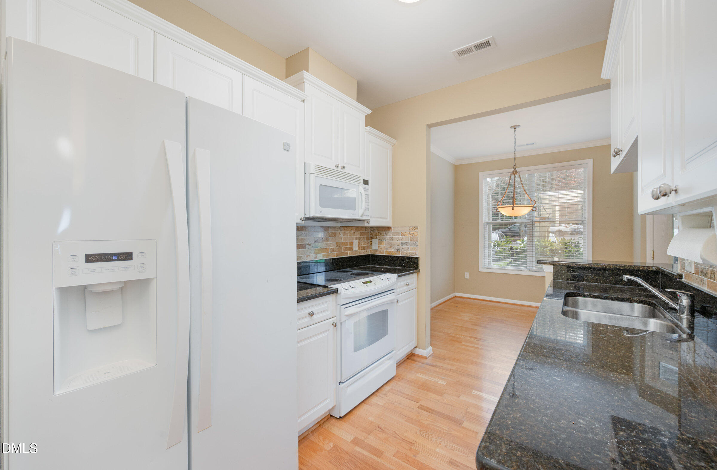 8041 Allyns Landing Way, Unit 101 Raleigh, NC 27615 - Photo 14 of 32 a kitchen with granite countertop a stove and a refrigerator