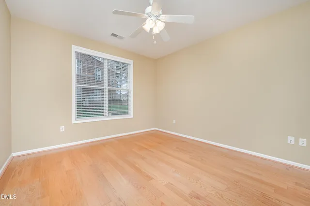 an empty room with a window and a ceiling fan