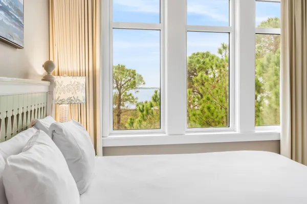 a bedroom with a bed flat screen tv and a large window