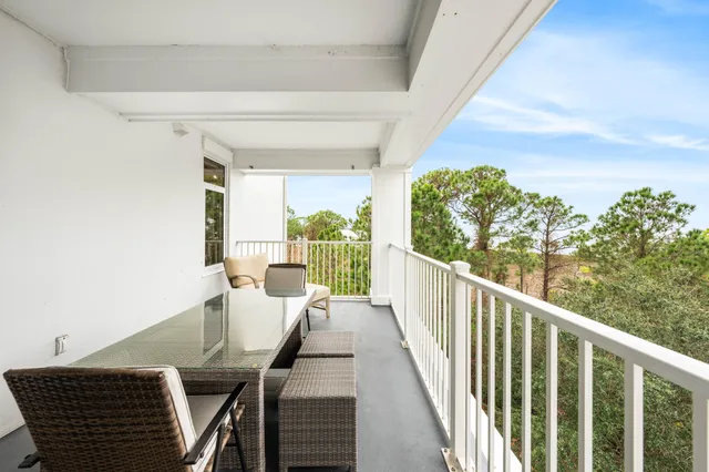 a bedroom with a bed a large window and table