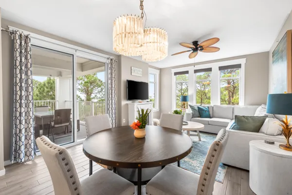a view of a dining room with furniture a chandelier and wooden floor
