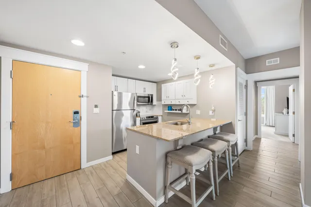 a kitchen with kitchen island a refrigerator and a table