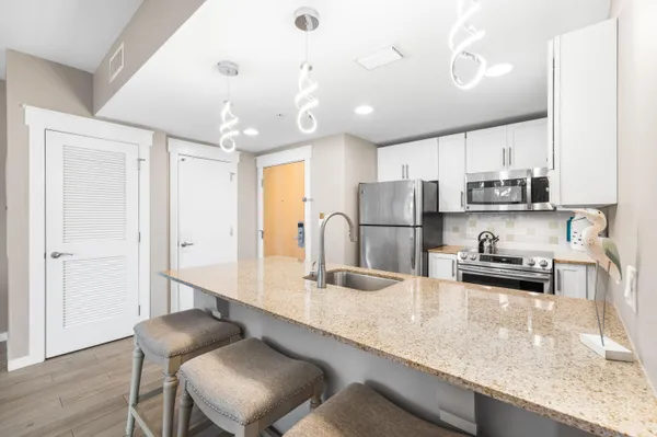 a kitchen with stainless steel appliances granite countertop a sink refrigerator and cabinets