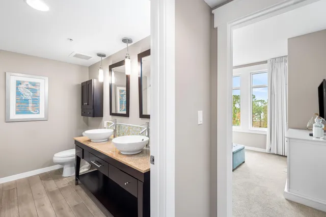a bathroom with a granite countertop sink mirror and toilet
