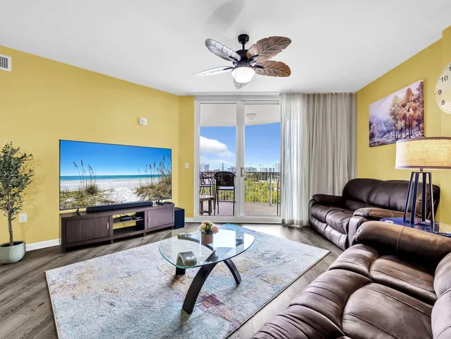 a living room with furniture ceiling fan and a rug