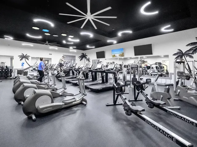 a living room with furniture gym equipment and large mirror