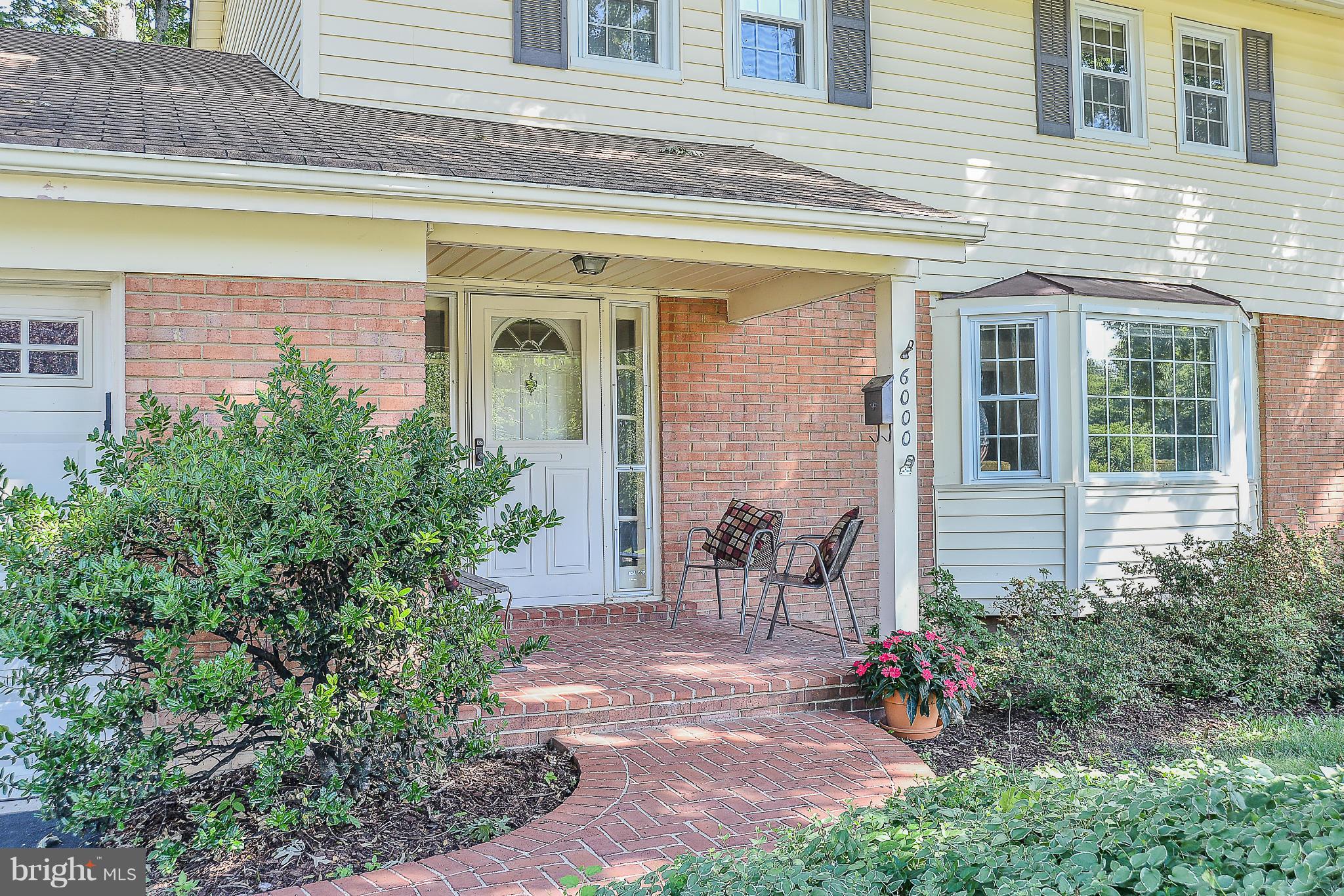 6000 Filbert Court Springfield, VA 22152 - Photo 2 of 21 a view of a brick house with potted plants and a table and chairs