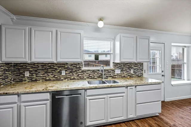 a kitchen with stainless steel appliances granite countertop white cabinets and sink