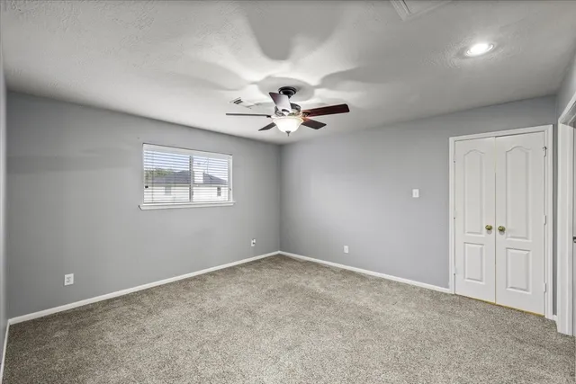 a view of an empty room with a ceiling fan