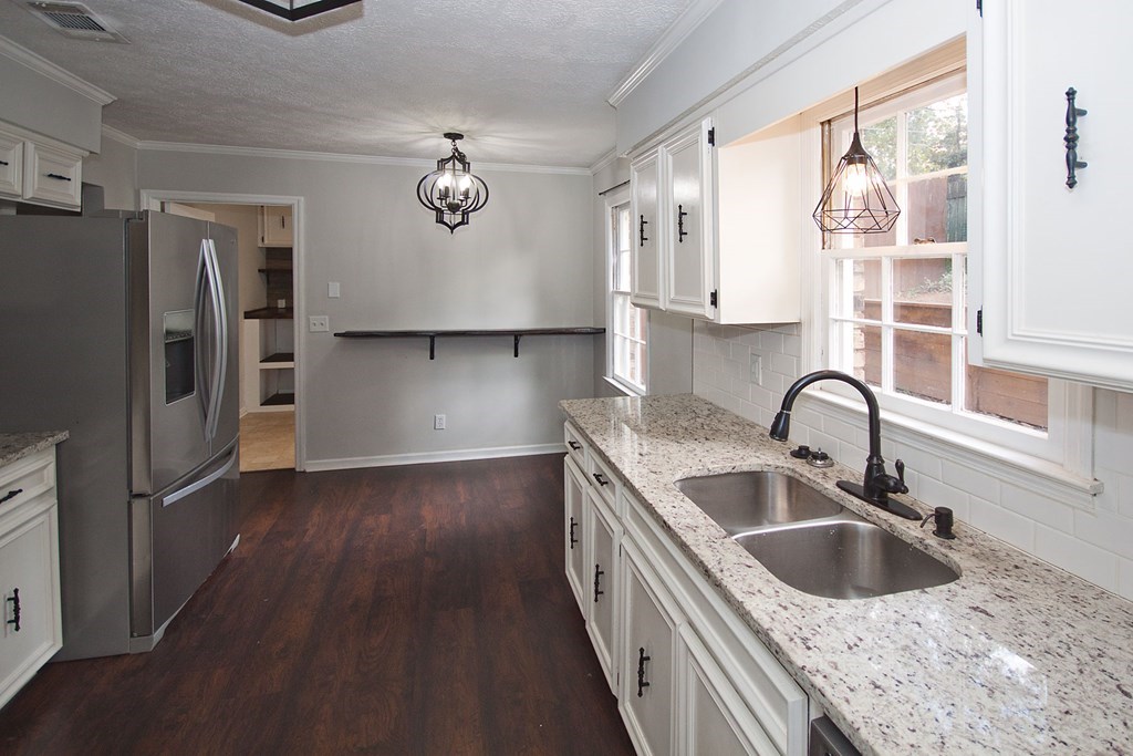 6838 Buckeye Way Columbus, GA 31904 - Photo 11 of 34 a kitchen with stainless steel appliances granite countertop a sink dishwasher a refrigerator and cabinets with wooden floor