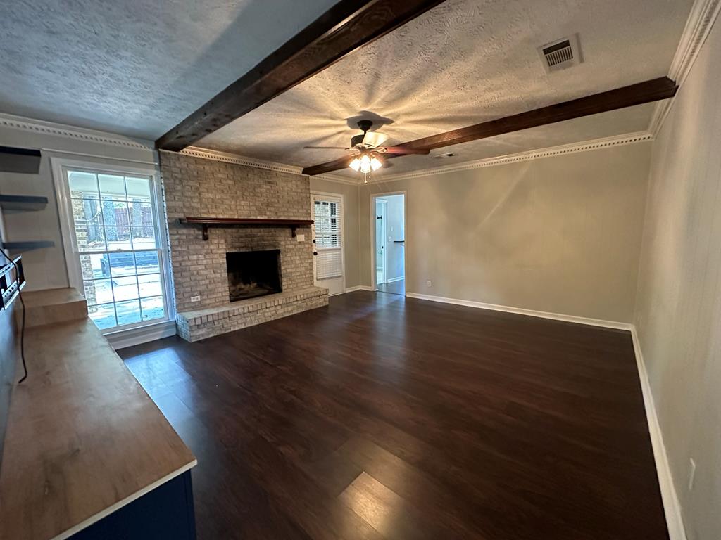6838 Buckeye Way Columbus, GA 31904 - Photo 13 of 34 an empty room with wooden floor a ceiling fan a fireplace and windows