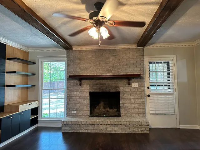 a living room with hard wood floors and a fireplace