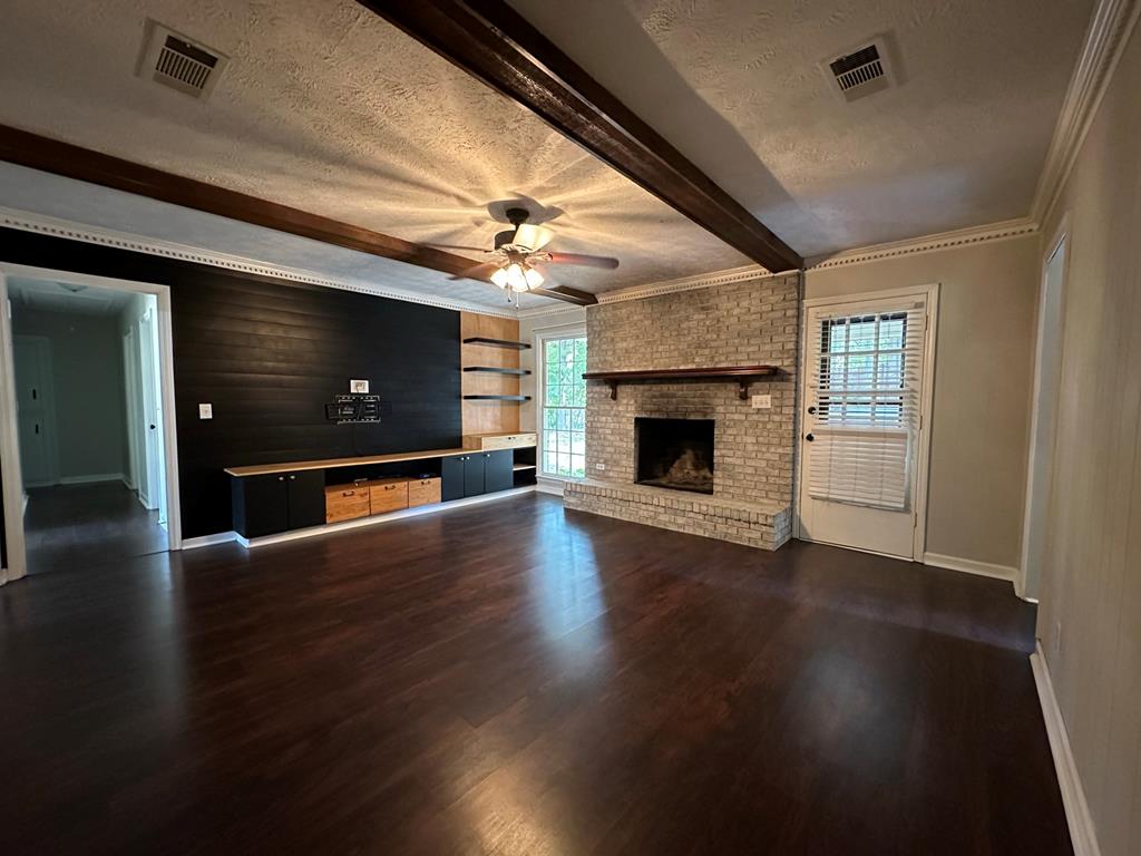 6838 Buckeye Way Columbus, GA 31904 - Photo 16 of 34 an empty room with wooden floor fireplace and windows
