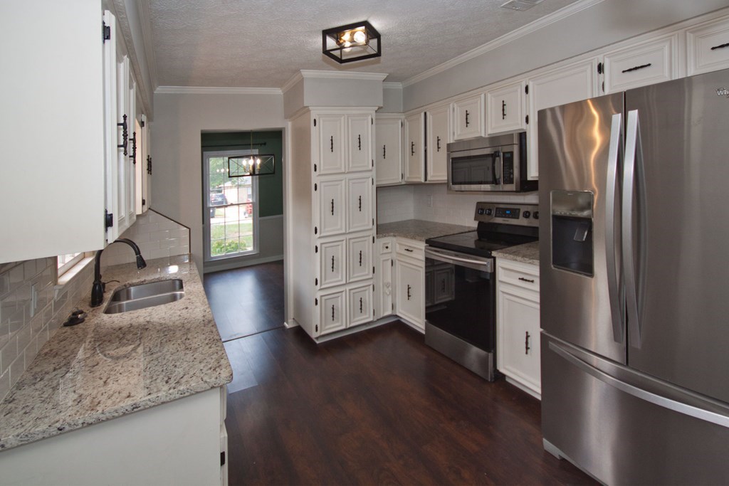 6838 Buckeye Way Columbus, GA 31904 - Photo 10 of 34 a kitchen with stainless steel appliances granite countertop a refrigerator a stove and a sink with wooden floor