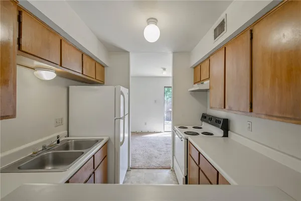 a kitchen with stainless steel appliances granite countertop a sink and a refrigerator