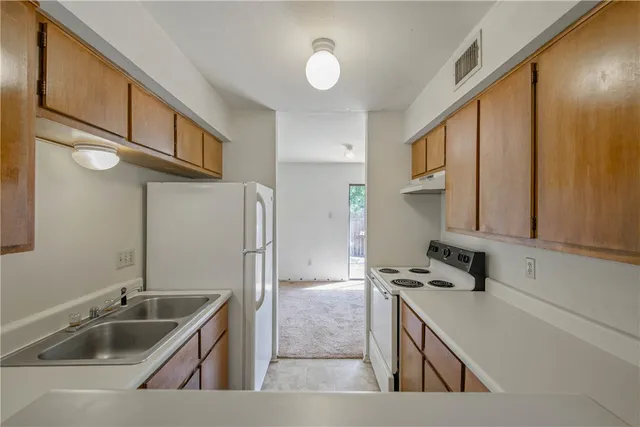 a kitchen with stainless steel appliances granite countertop a sink and a refrigerator