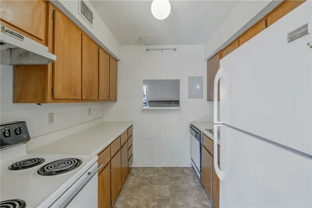 a kitchen with a refrigerator a stove top oven a sink and cabinets