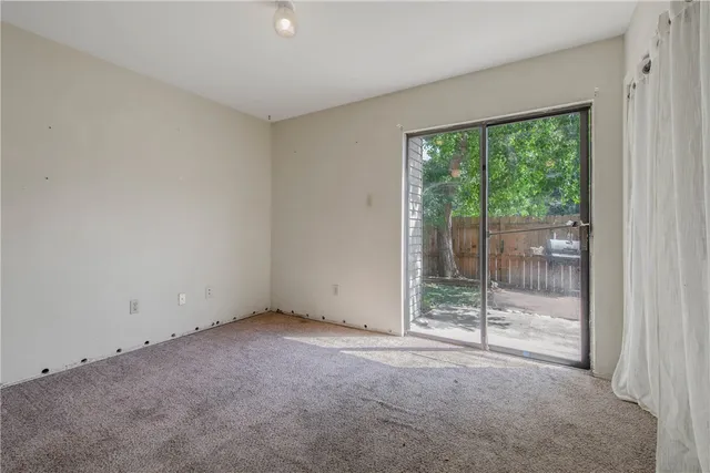 an empty room with sliding glass door and shower