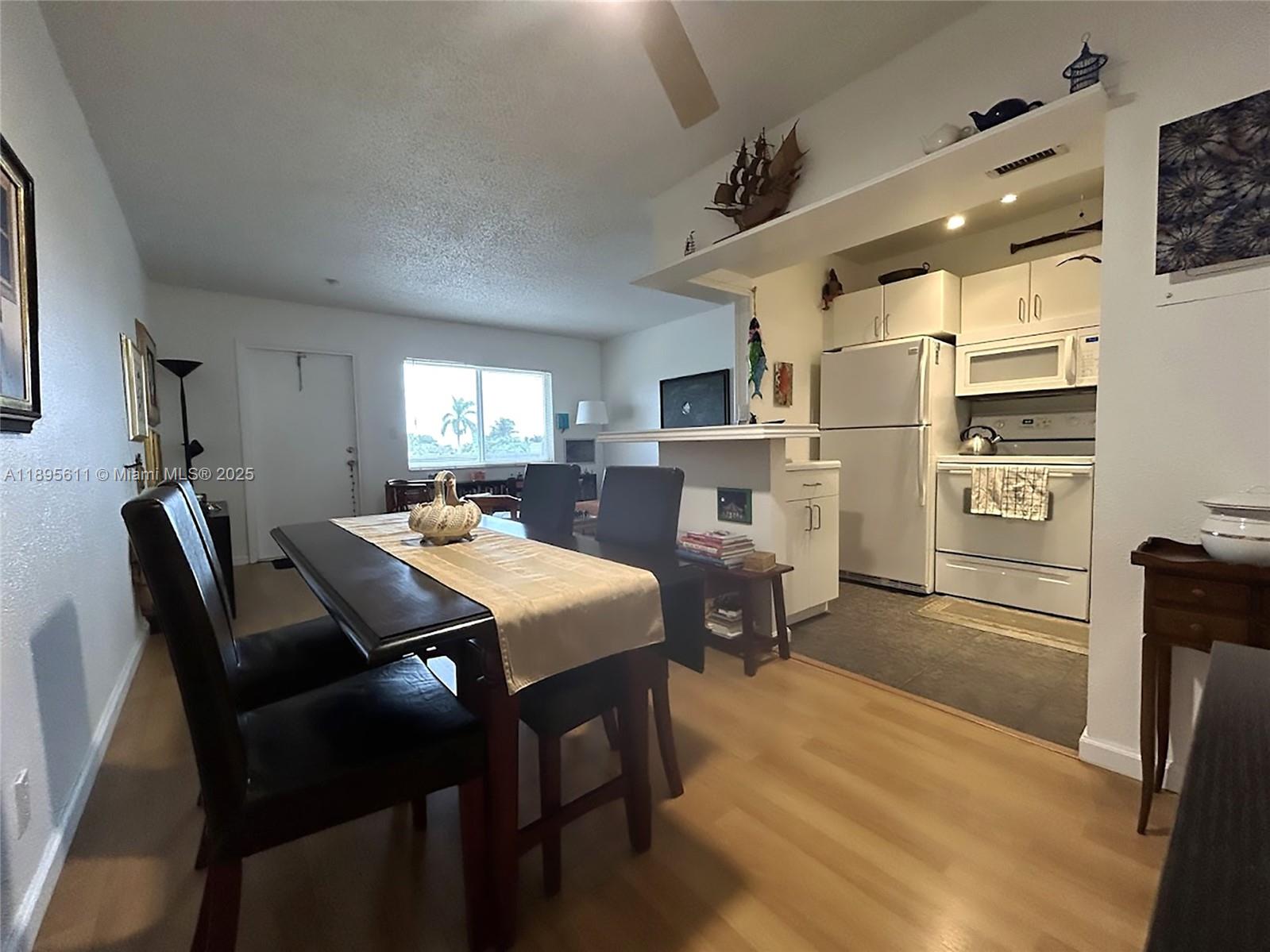 1400 Northeast 54th Street, Unit 306 Fort Lauderdale, FL 33334 - Photo 4 of 12 a view of a dining room with furniture and a chandelier