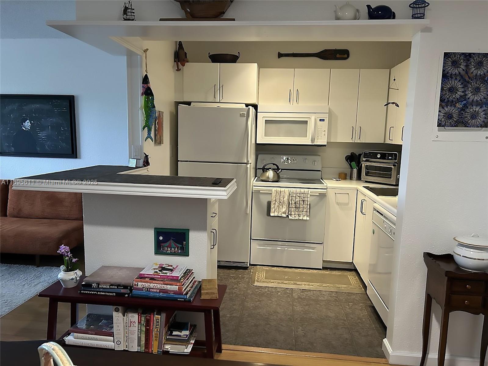 1400 Northeast 54th Street, Unit 306 Fort Lauderdale, FL 33334 - Photo 5 of 12 a kitchen with cabinets and appliances